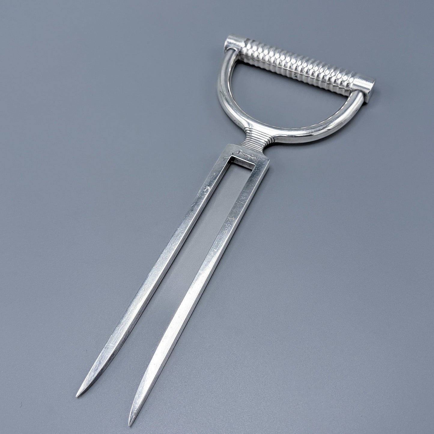 Sterling Silver Carving Fork  with a D-shaped handle on a gray background